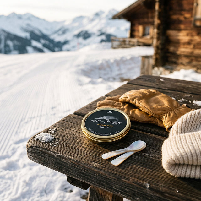 Boîte de caviar Eichinger Imperial Baerii avec deux cuillères en nacre sur un banc en bois dans la neige