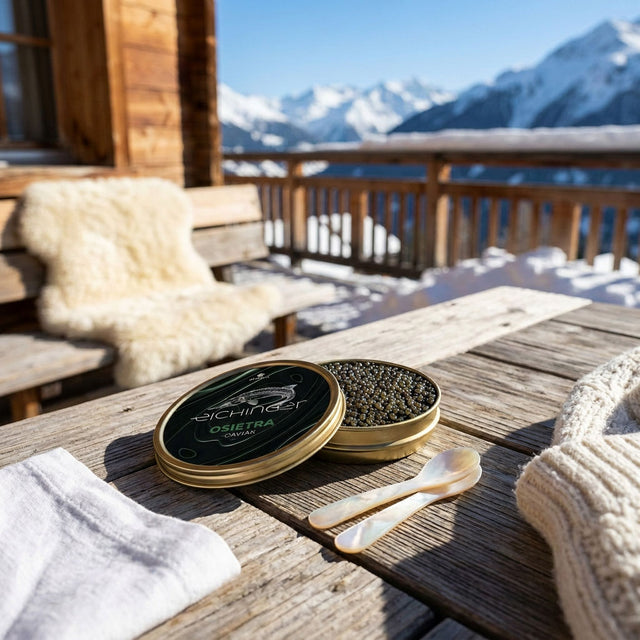 Open tin of Eichinger Osietra caviar with two mother-of-pearl spoons on a chalet terrace with snowy peaks behind